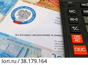 Налоговое уведомление, калькулятор и российские деньги (2022 год). Редакционное фото, фотограф Цибаев Алексей / Фотобанк Лори
