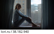 Silhouette of a woman sitting near the window. Стоковое видео, видеограф Татьяна Чудакова / Фотобанк Лори