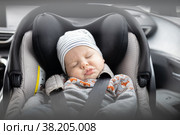 Cute little baby boy sleeping strapped into infant car seat in passenger compartment during car drive. Стоковое фото, фотограф Matej Kastelic / Фотобанк Лори
