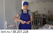 Discontented teenager boy holding bunch of money he earned by working on his first job in construction site. Стоковое видео, видеограф Яков Филимонов / Фотобанк Лори