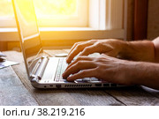 Hands of a man working at a computer laptop by the window in the sunlight. Стоковое фото, фотограф Андрей С / Фотобанк Лори
