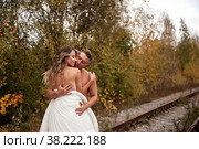 Young cute couple on their honeymoon woman and man embrace in their bed on railway tracks. Concept of romantic travel ban and inability to move. Stay at home. Copying space for a site. Стоковое фото, фотограф Aleksandr Golubev / Фотобанк Лори