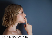 Closeup pretty portrait of young woman. Female with finger on lips against dark insulation background. Female emotion happy and actress of master. Concept of satisfaction and inspiration. Copyright space. Стоковое фото, фотограф Aleksandr Golubev / Фотобанк Лори