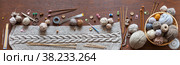 Panoramic top view of hand knitted warm scarf with voluminous braid. Skeins of wool yarn in basket and knitting accessories on wooden background. Craft and DIY concept. Banner, copy space, mock up. Стоковое фото, фотограф Виктория Катьянова / Фотобанк Лори