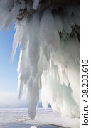 Baikal Lake on a sunny winter day. View from the ice grotto with long icicles in the rocks of Olkhon Island to the frozen Small Sea Strait. Unusual landscape. Natural winter background. Стоковое фото, фотограф Виктория Катьянова / Фотобанк Лори