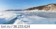 Beautiful winter landscape of frozen Lake Baikal with ice hummocks and ice breaks. The Great Baikal Trail of tourists is visible on the coastal hill. Panoramic view. Natural background. Ice travel. Стоковое фото, фотограф Виктория Катьянова / Фотобанк Лори