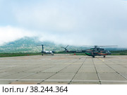 Helicopter and plane at the airport of Kunashir island preparing for takeoff (2022 год). Редакционное фото, фотограф Евгений Харитонов / Фотобанк Лори