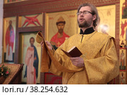 Диакон читает молитву во время утренней литургии в Никольском храме села Васютино (2022 год). Редакционное фото, фотограф Дмитрий Неумоин / Фотобанк Лори