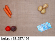 Картофель, свекла, помидор, морковь и российские деньги на тканевом фоне из мешковины. Стоковое фото, фотограф Цибаев Алексей / Фотобанк Лори