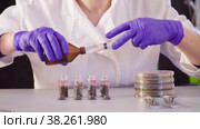 The scientists hands pouring solvent into the bottles. Стоковое видео, видеограф Chudakov_Ivan / Фотобанк Лори