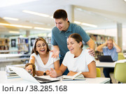 Loud young students laughing together with a laptop. Стоковое фото, фотограф Яков Филимонов / Фотобанк Лори