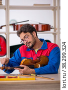 Young man repairing musical instruments at workshop. Стоковое фото, фотограф Elnur / Фотобанк Лори