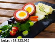 Scotch egg srved with mashed potatoes and greens, Scottish traditional dish. Стоковое фото, фотограф Яков Филимонов / Фотобанк Лори