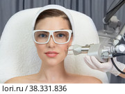 Therapist beautician makes a laser rejuvenation for the model by apparatus in a beauty salon. Стоковое фото, фотограф Юлия Тарасова / Фотобанк Лори