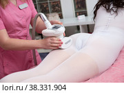 Woman in white suit getting LPG anti cellulite massage in a beauty SPA salon. Стоковое фото, фотограф Юлия Тарасова / Фотобанк Лори