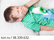 Больному мальчику меряют температуру и он кашляет. Стоковое фото, фотограф Скляров Роман / Фотобанк Лори