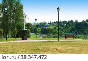 City park with benches on the embankment. Burial place of the Rzhev archpriest Matthew Konstantinovsky 1791-1857. Europe, Russia, Rzhev. This holy cross was erected near the burial place of the Rzhev Archpriest Matthew Konstantinovsky 1791 - 1857 years of piety ascetic of the 19th century. (2021 год). Редакционное фото, фотограф Алексей Сорокин / Фотобанк Лори