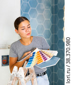 Young woman selects a harmonious color of paint with existing. Стоковое фото, фотограф Яков Филимонов / Фотобанк Лори