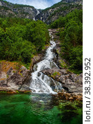 Mountain landscape with a beautiful waterfall and cloudy sky . Beautiful nature of Norway. The Geiranger Fjord. Стоковое фото, фотограф Оксана Медведева / Фотобанк Лори