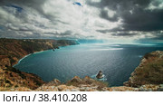 A large sea bay surrounded by a steep rocky shore, on the water a shadow of dramatic rain clouds in the sky, a wide panorama. Long shot taken with a tripod. Стоковое видео, видеограф Даниил Хабаров / Фотобанк Лори