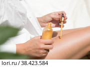 Косметология, уход, омоложение, спа-косметические средства, концепция красоты, молодости и бикини. Женщина в белой рубашке мажет ноги мерцающим увлажняющим кремом. Стоковое фото, фотограф Photojuli / Фотобанк Лори