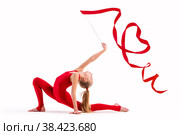 Girl gymnast in red overalls does exercise with a ribbon on white background, the ribbon curled into a heart, isolate. Стоковое фото, фотограф Мария Мороз / Фотобанк Лори