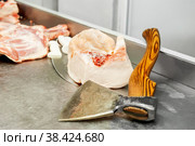 Подготовка мяса к продаже в мясной лавке. Старый топор для разделки туш лежит на колоде для рубки мяса. Мясной отдел рынка. Стоковое фото, фотограф Оксана Медведева / Фотобанк Лори