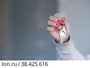 Добро пожаловать в новый дом. Крупный план молодой женщины, держащей в руке связку ключей с брелком в виде домика. Агент по недвижимости, риэлтор, который дает вам ключ от новой квартиры. Стоковое фото, фотограф Photojuli / Фотобанк Лори