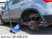 Сar at the tire mounting with removed wheel on pneumatic jack. Стоковое фото, фотограф FotograFF / Фотобанк Лори