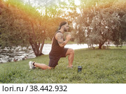 Brawny handsome bearded man sportsman with cap doing sport exercising outside in urban park with greenery. Fitness healthy lifestyle concept with male athlete, exercising outdoors. Copy text space. Стоковое фото, фотограф Aleksandr Golubev / Фотобанк Лори