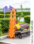 Special orange plastic medical stretcher in the city park (2022 год). Редакционное фото, фотограф FotograFF / Фотобанк Лори