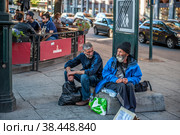 Norway, Oslo August 01 2013. Two elderly men ask for alms, sitting on the street in front of the cafe. The concept of indifference of the state to the poverty of people. Редакционное фото, фотограф Оксана Медведева / Фотобанк Лори