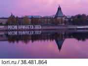 Надпись-инсталяция "Россия начинается здесь" на фоне Псковского кремля в октябрьским сумерки (2018 год). Редакционное фото, фотограф Виктор Карасев / Фотобанк Лори