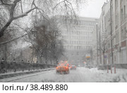 На заснеженной Неглинной улице в Москве перед поворотом на Рахмановский переулок. Вид на январскую непогоду в городе через мокрое стекло автомобиля (2021 год). Редакционное фото, фотограф Наталья Николаева / Фотобанк Лори