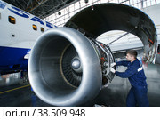 Россия. Санкт-Петербург. Авиационная отрасль. Авиамеханик авиакомпании "Трансаэро" ремонтирует двигатель самолета. Russia. Saint-Petersburg. Aviation industry. The aircraft mechanic of Transaero Airlines repairs the aircraft engine (2012 год). Редакционное фото, фотограф Алексей Смышляев / Фотобанк Лори