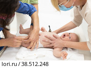 Baby beeing vaccinated by pediatrician in presence of his mother. Preventive vaccination against Diphtheria, whooping cough, tetanus, hepatitis, haemophilus influenzae, pneumococcus, poliomyelitis. Стоковое фото, фотограф Matej Kastelic / Фотобанк Лори