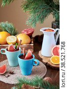 Mulled wine in blue glasses. Fruits. Orange, grapefruit, lemon, pomegranate, mint. Bright colors. Spruce branches decoration. Side view. Wooden-material. Стоковое фото, фотограф Лютик Фалисова / Фотобанк Лори