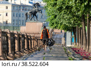 Россия. Санкт-Петербург. Дворник подметает набережную реки Фонтанка. Russia. Saint-Petersburg. A janitor sweeps the Fontanka River embankment. (2022 год). Редакционное фото, фотограф Алексей Смышляев / Фотобанк Лори