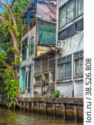 A serene warren of canals, floating houses and stilt houses over the Chao Phraya River, at Krung Thon Bridge (Saphan Sang Hi) (2019 год). Стоковое фото, фотограф Анна Кривицкая / Фотобанк Лори