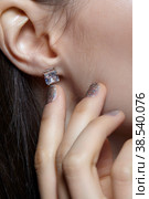 Female posing with hand near face. In the ear is an earring with a white crystal stone. Стоковое фото, фотограф Сергей Пристяжнюк (Serg Zastavkin) / Фотобанк Лори