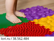 Child feet on orthopedic baby massage puzzle floor mats with colorful details for preventing flatfoot. Стоковое фото, фотограф Photojuli / Фотобанк Лори
