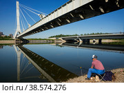 Россия. Санкт-Петербург. Человек ловит рыбу. Рыбак удит на рабылке. Russia. Saint-Petersburg. A man is fishing. A fisherman is fishing on a fishing trip. (2016 год). Редакционное фото, фотограф Алексей Смышляев / Фотобанк Лори