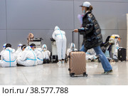 Россия. Москва. Студенты китайского Чаньчуньского университета в защитных костюмах в аэропорту Шереметьево. Russia. Moscow. Students of the Chinese Changchun University in protective suits at Sheremetyevo Airport. (2021 год). Редакционное фото, фотограф Алексей Смышляев / Фотобанк Лори