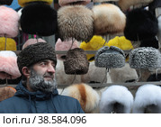 Курбан из Дагестана продаёт головные уборы на Измайловском Вернисаже (2022 год). Редакционное фото, фотограф Дмитрий Неумоин / Фотобанк Лори