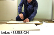 Wooden modular rack. Assembling a modular rack. A man installs an eccentric rod. Стоковое видео, видеограф Vadzim Yakubovich / Фотобанк Лори