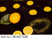 Узбекский лимон целиком и половинки, рассыпанная карамельная крошка на чёрном фоне. Стоковое фото, фотограф Татьяна Бакуменко / Фотобанк Лори