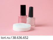 Two pink nail polishes and cotton pads on pink background. Стоковое фото, фотограф Попова Ольга / Фотобанк Лори