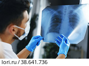 Male doctor examines an x-ray of lungs in hospital. Стоковое фото, фотограф Сергей Толмачёв / Фотобанк Лори