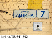 Город Королев, Московская область. Адресная табличка с названием улицы  "Улица Ленина, 7" на кирпичной стене дома. Табличка с надписью: "Класс энергетической эффективности "Е", пониженный" (2021 год). Стоковое фото, фотограф Наталья Николаева / Фотобанк Лори