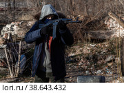 A grown man wearing a mask, wearing a jacket with a hood, wearing military pants, wearing gloves aims at a weapon. Стоковое фото, фотограф Владимир Арсентьев / Фотобанк Лори